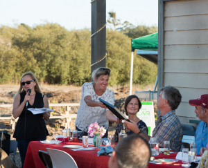 Publisher Sarah Wood and Ad Manager Shelby Lambert present a Local Heroes award to Tom Broz of Life Earth Farm